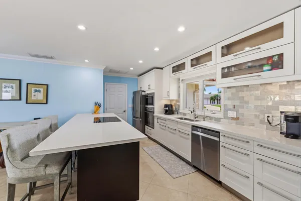 a kitchen with a table chairs sink and cabinets