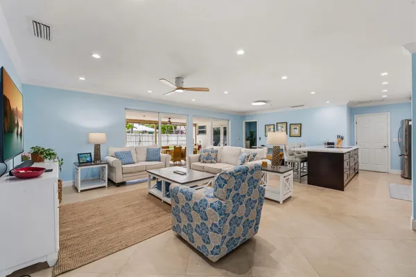 a living room with furniture a flat screen tv and kitchen view