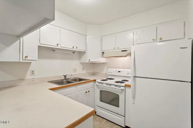 a kitchen with a white cabinets and white appliances