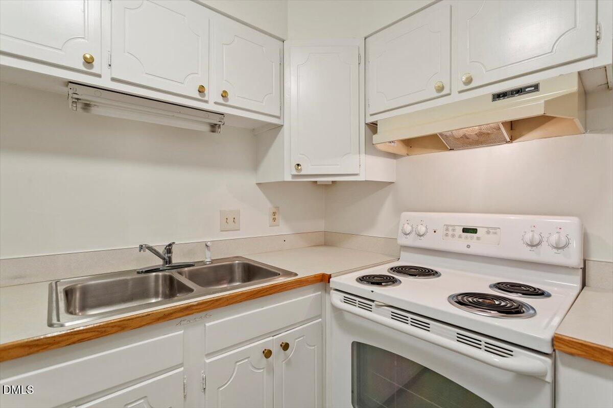 1217 H Manassas Court, Unit H Raleigh, NC 27609 - Photo 15 of 30 a kitchen with sink a stove and wooden cabinets