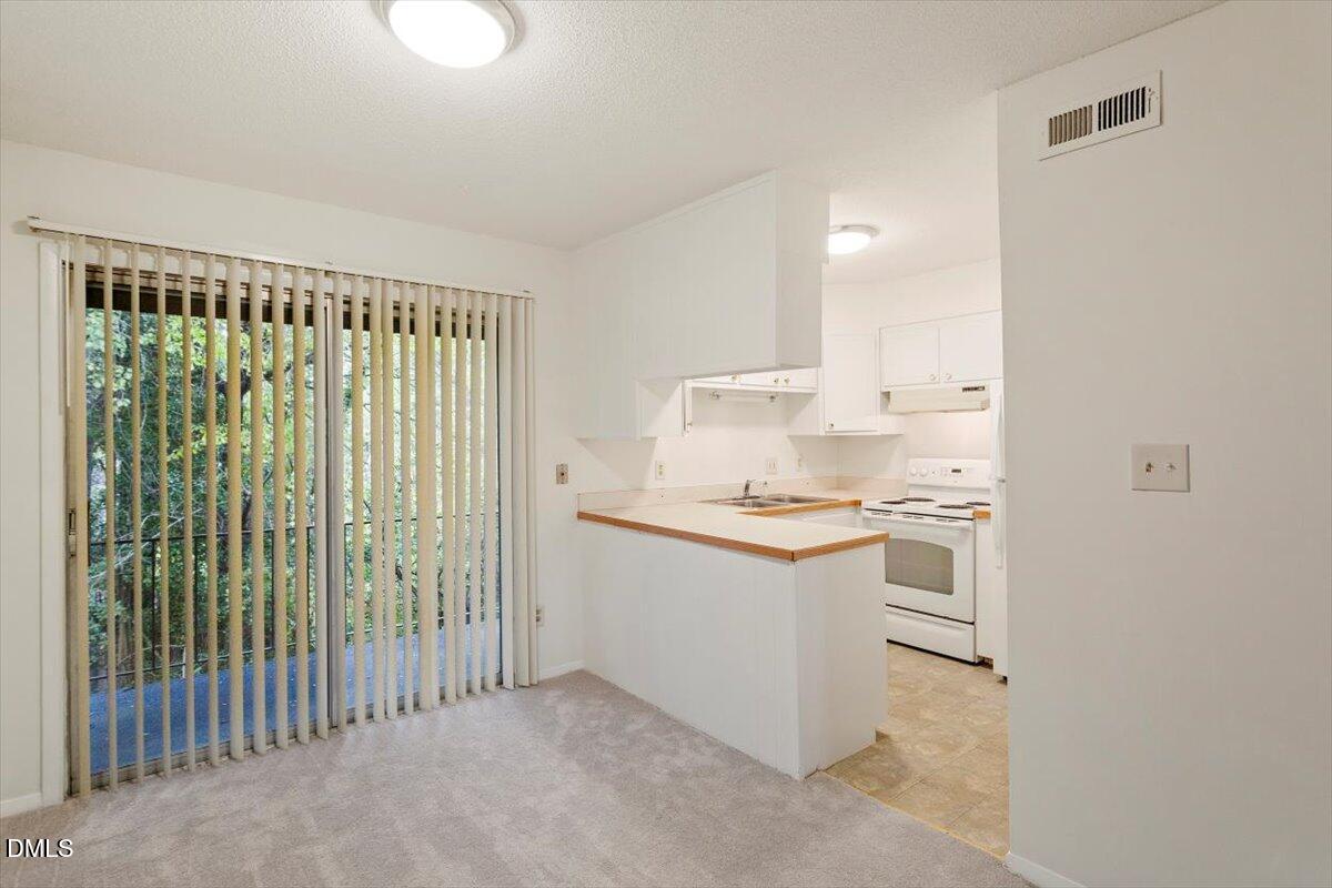 1217 H Manassas Court, Unit H Raleigh, NC 27609 - Photo 9 of 30 a kitchen with a sink and white cabinets