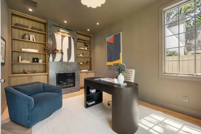a living room with furniture a fireplace and a large window