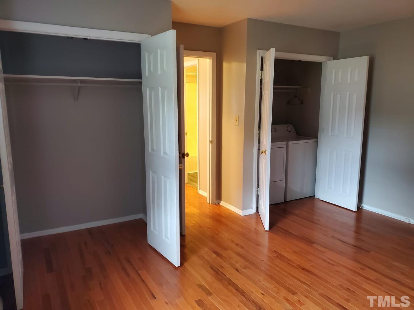 an empty room with wooden floor and closet