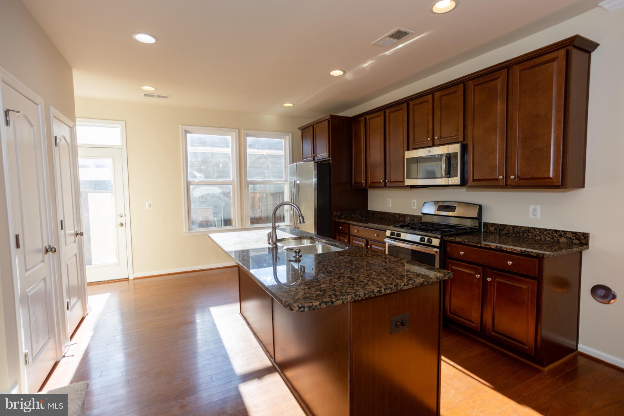 8941 Quarry Road Manassas, VA 20110 - Photo 14 of 44 Modern kitchen with rich wood cabinetry.