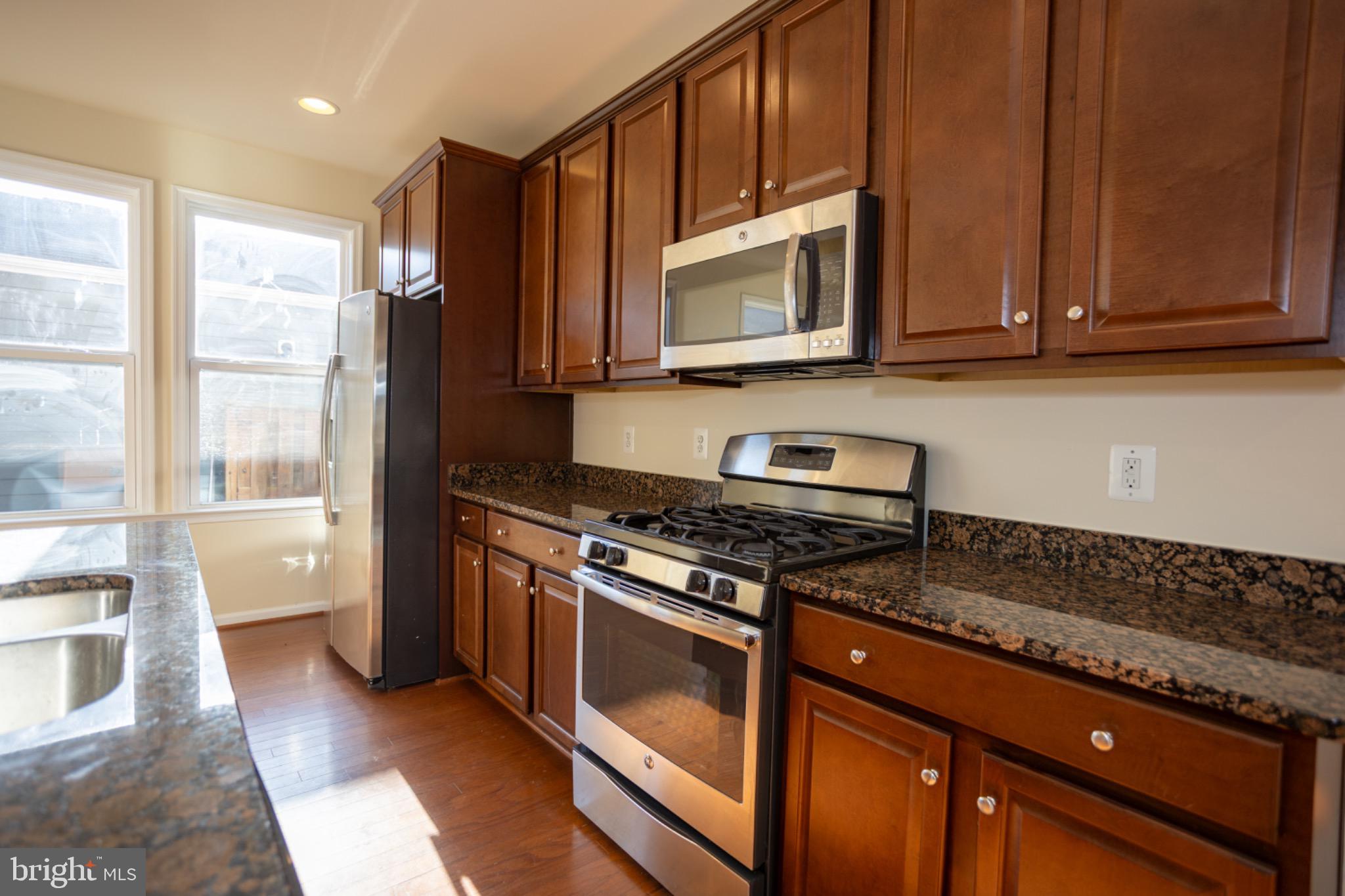 8941 Quarry Road Manassas, VA 20110 - Photo 16 of 44 Modern kitchen with rich wood cabinetry.