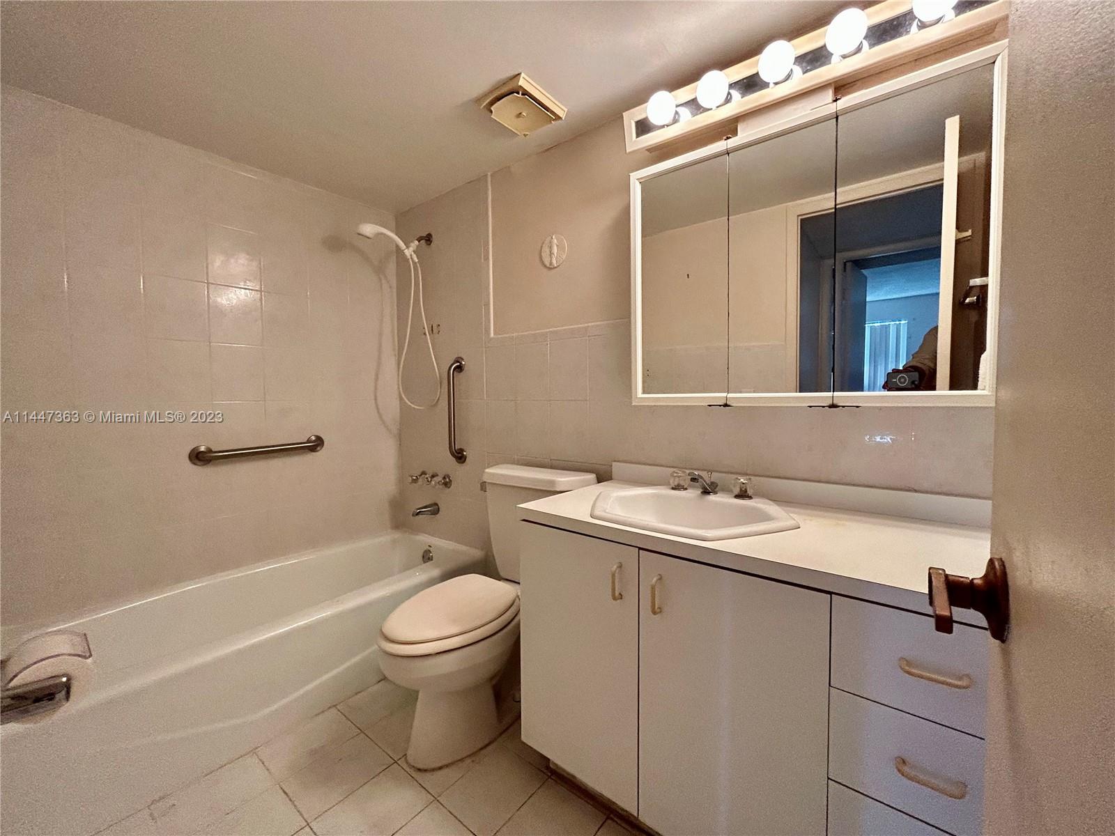 5201 Northwest 7th Street, Unit 403 Miami, FL 33126 - Photo 12 of 17 a bathroom with a sink a toilet and shower