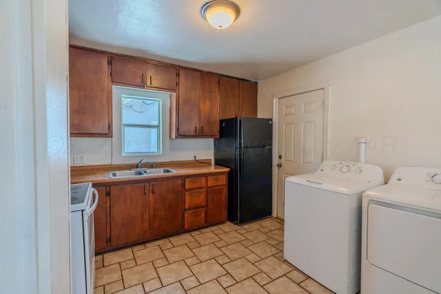 a kitchen with a refrigerator and a stove top oven