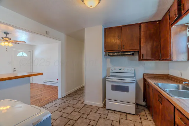 a kitchen with a sink a stove and cabinets