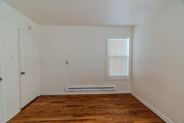 a view of a room with wooden floor and white walls