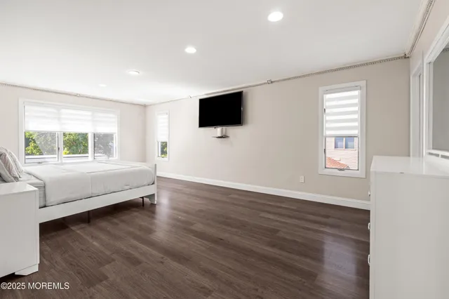 a living room with couch wooden floor and a flat screen tv