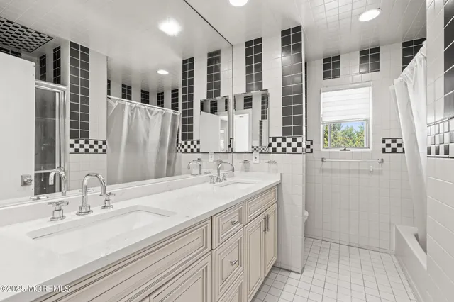 a bathroom with double vanity sinks a mirror and a shower
