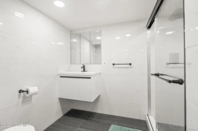 a bathroom with a sink a toilet a mirror and shower