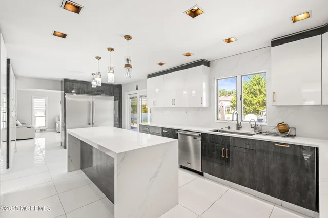 a kitchen with a sink a counter top space and stainless steel appliances