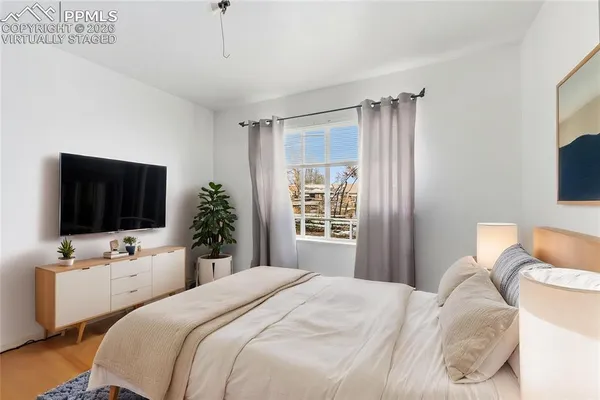 a bedroom with a bed television and a window
