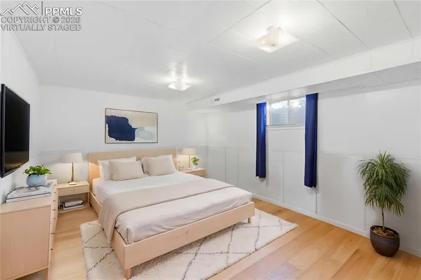 a bedroom with a large bed and a potted plant