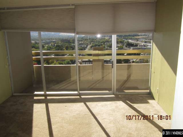 100 North Arlington Avenue, Unit 19H Reno, NV 89501 - Photo 3 of 11 a glass door with glass top table and chairs
