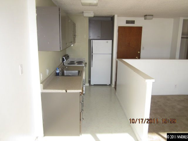 100 North Arlington Avenue, Unit 19H Reno, NV 89501 - Photo 6 of 11 a kitchen with a refrigerator and a stove
