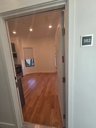 a view of a hallway with wooden floor