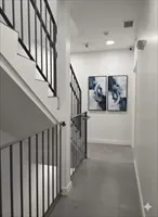 a view of staircase with lots of frames on wall and a painting