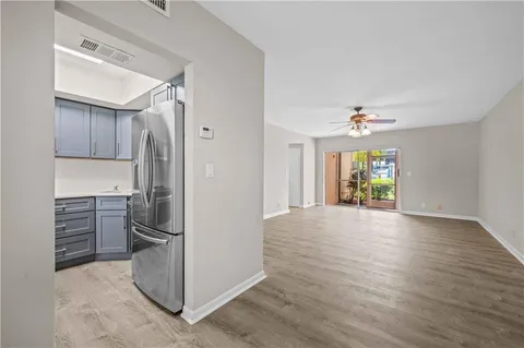 a view of a kitchen with a sink refrigerator and wooden floor