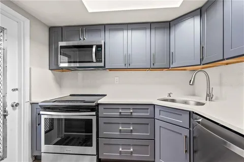 a kitchen with cabinets stainless steel appliances and a sink