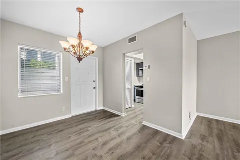 a view of a livingroom with wooden floor and a chandelier