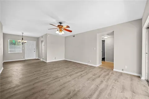 a view of an empty room with window and wooden floor