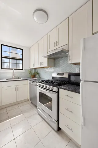 a bedroom with a large bed and two windows