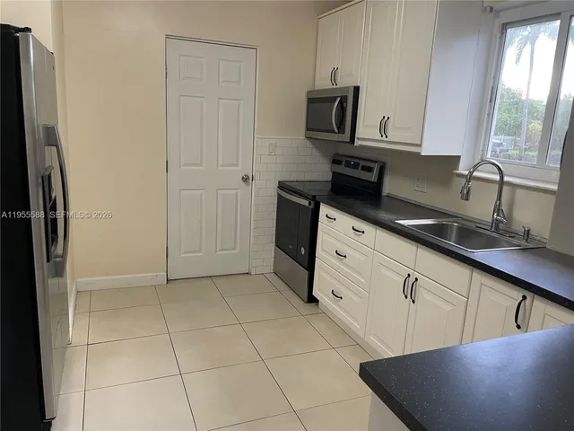a kitchen with a sink a stove and cabinets
