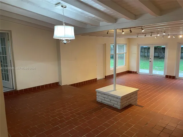 a living room with couch cabinet and a potted plant