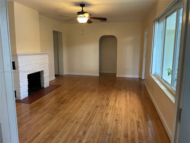 wooden floor in an empty room with a fireplace