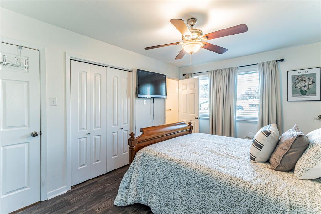 708 North Stewart Street Azle, TX 76020 - Photo 12 of 25 a bedroom with a large bed and a ceiling fan