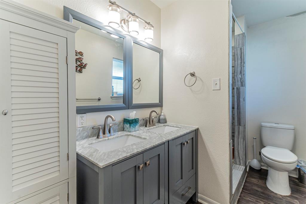 708 North Stewart Street Azle, TX 76020 - Photo 14 of 25 a bathroom with a granite countertop sink a toilet and a mirror