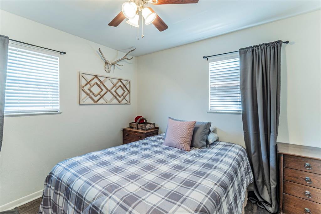 708 North Stewart Street Azle, TX 76020 - Photo 16 of 25 a bedroom with a bed and a chandelier