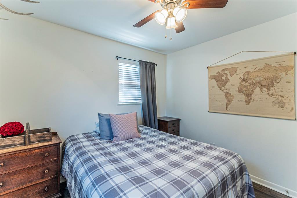 708 North Stewart Street Azle, TX 76020 - Photo 17 of 25 a bedroom with a bed and a chandelier