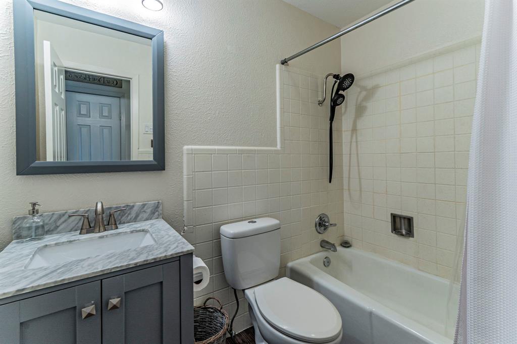 708 North Stewart Street Azle, TX 76020 - Photo 20 of 25 a bathroom with a granite countertop toilet a sink and bathtub