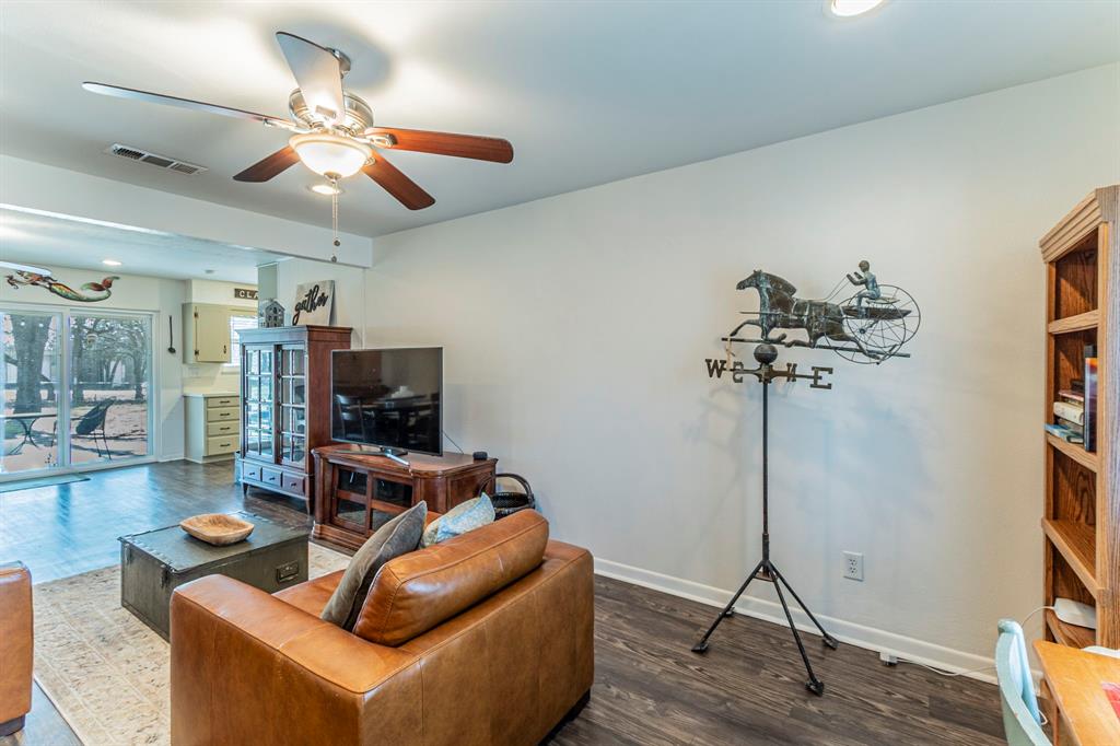 708 North Stewart Street Azle, TX 76020 - Photo 2 of 25 a living room with furniture a flat screen tv and a chandelier