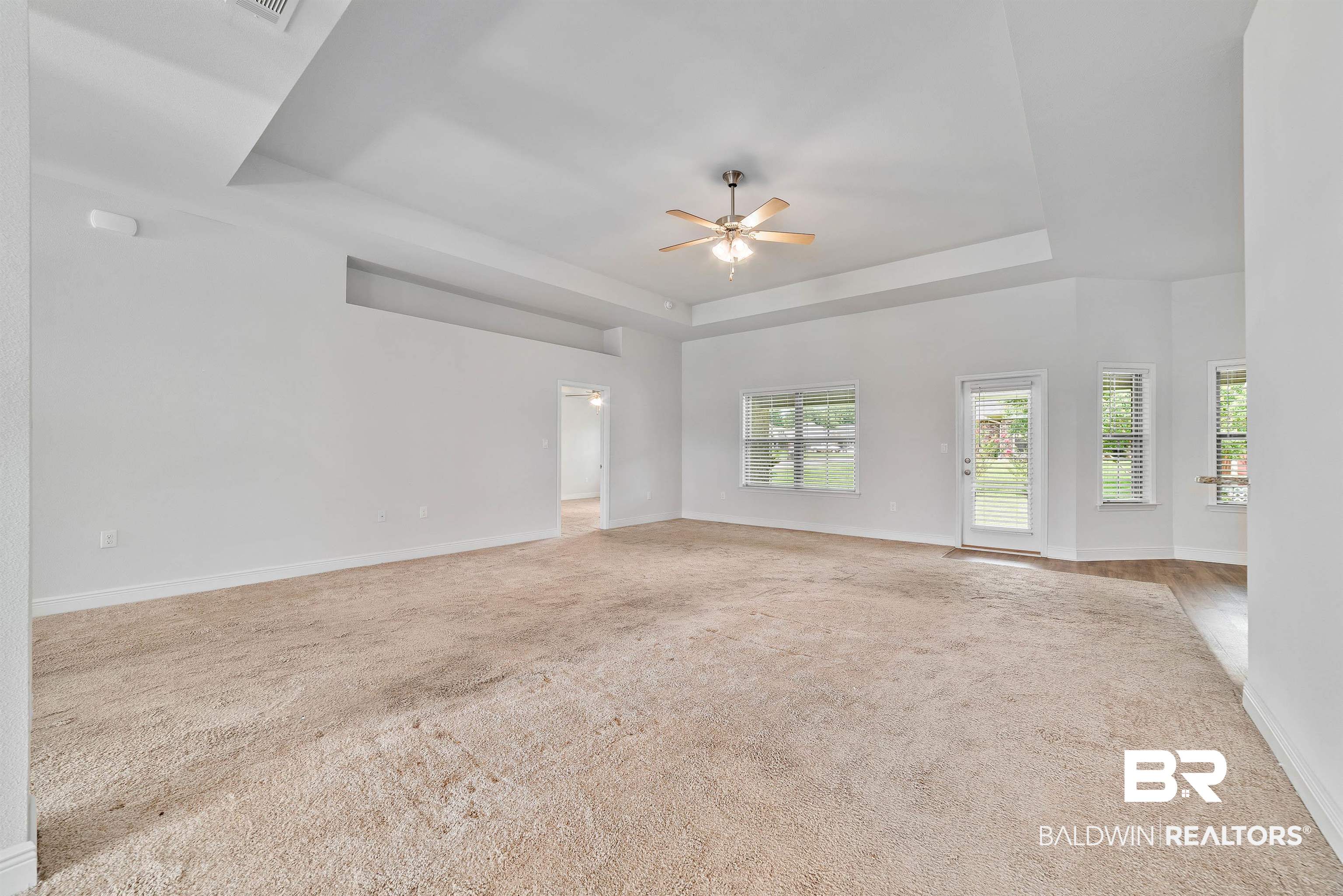 13155 Wishbone Court Foley, AL 36535 - Photo 18 of 39 Carpeted empty room featuring ceiling fan and a tray ceiling