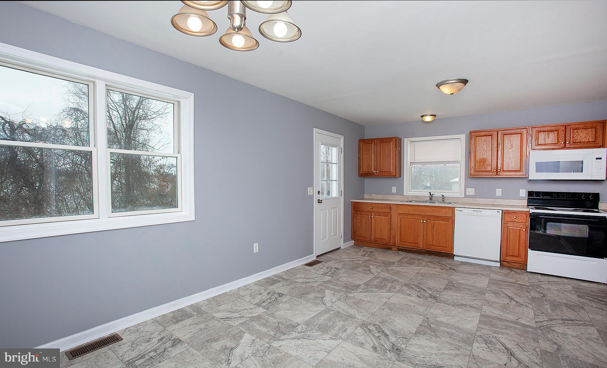 1031 Oberlin Road Middletown, PA 17057 - Photo 11 of 39 a large kitchen with stainless steel appliances granite countertop a stove a sink dishwasher and a white refrigerator with wooden floor