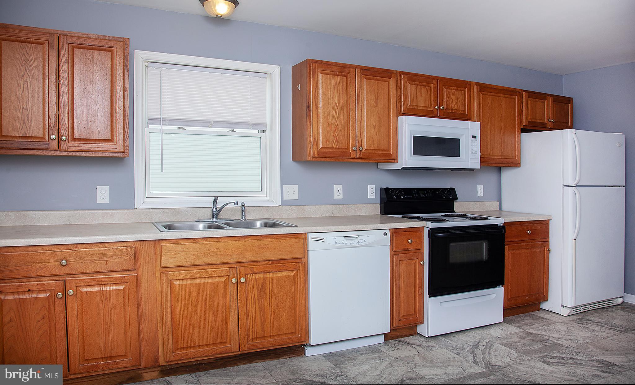 1031 Oberlin Road Middletown, PA 17057 - Photo 8 of 39 a kitchen with granite countertop a refrigerator stove top oven a sink and dishwasher