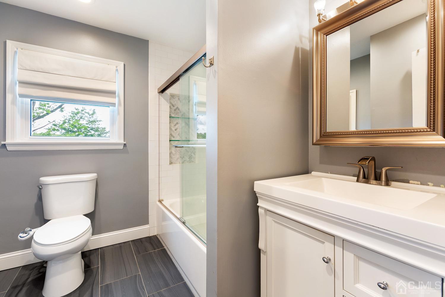 60 Wilcox Road New Brunswick, NJ 08901 - Photo 11 of 25 a bathroom with a toilet sink and mirror