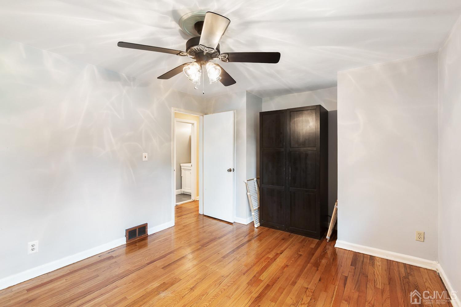 60 Wilcox Road New Brunswick, NJ 08901 - Photo 13 of 25 an empty room with wooden floor fan and windows