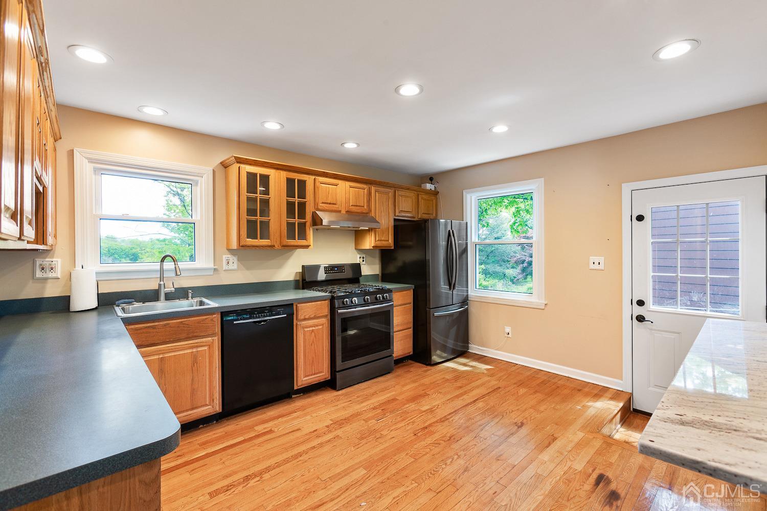60 Wilcox Road New Brunswick, NJ 08901 - Photo 7 of 25 a large kitchen with stainless steel appliances granite countertop a stove a sink a refrigerator and a granite counter tops with wooden floors
