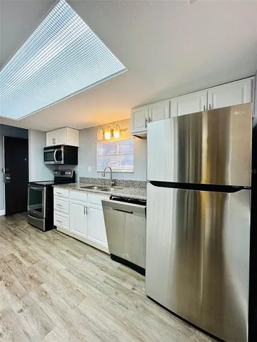 a kitchen with stainless steel appliances a refrigerator sink and microwave