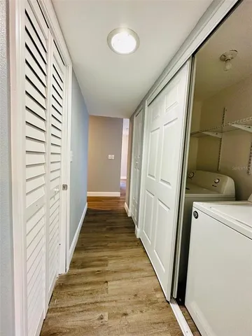 a view of a hallway with wooden floor and staircase