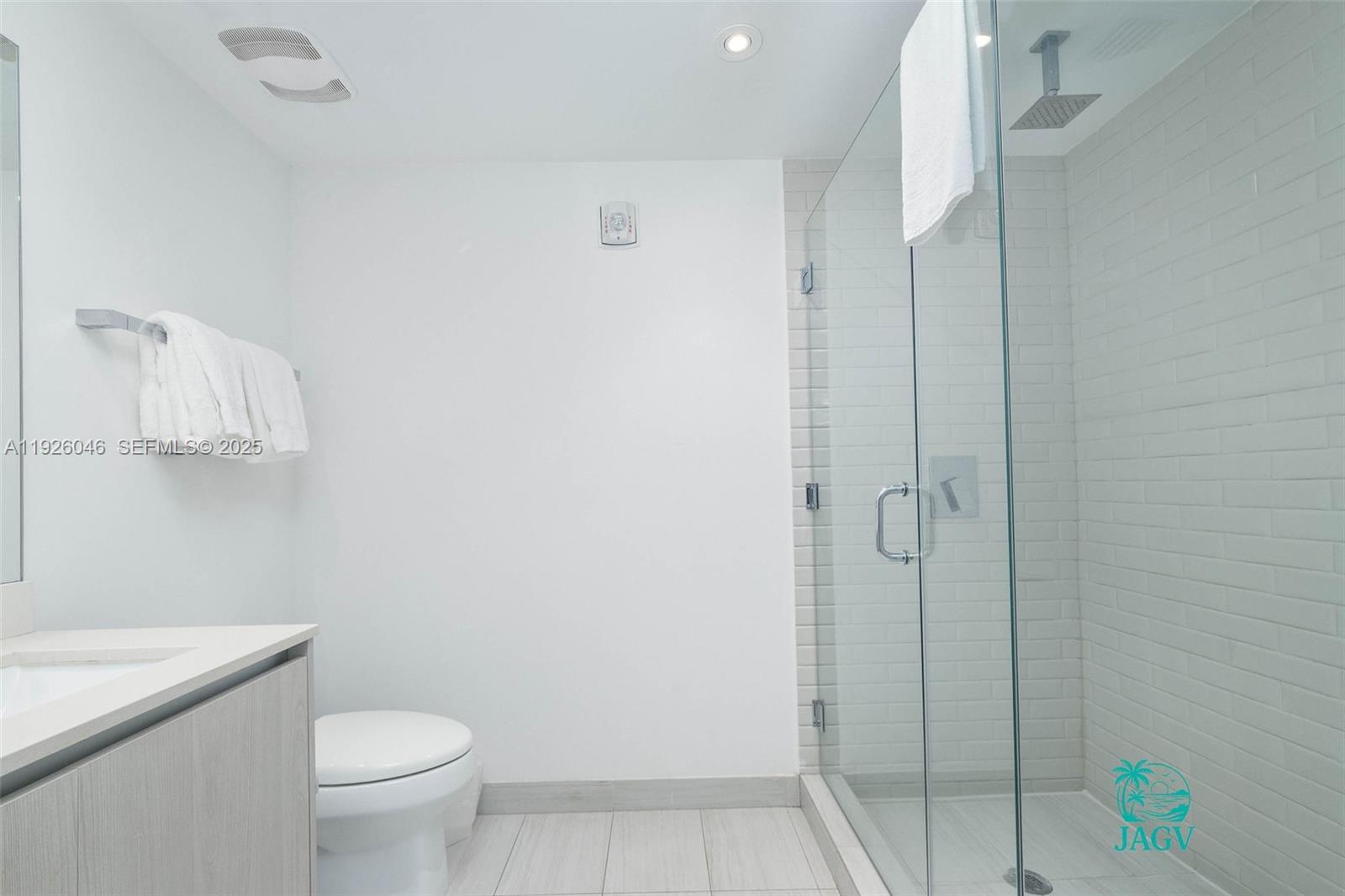 4010 South Ocean Drive, Unit R3005 Hollywood, FL 33019 - Photo 20 of 57 a bathroom with a granite countertop toilet a sink and shower