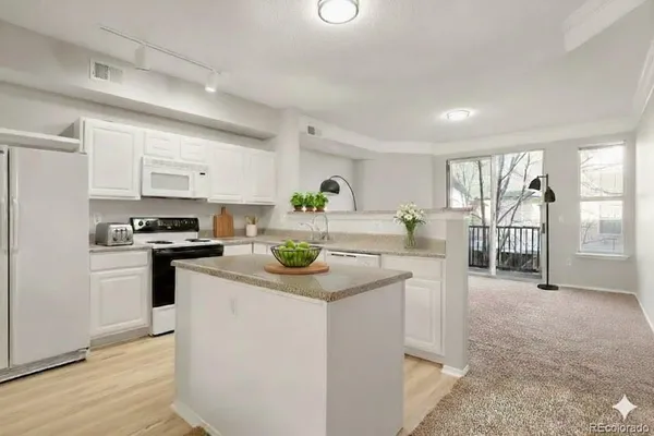 a kitchen with kitchen island granite countertop a stove a sink and a refrigerator