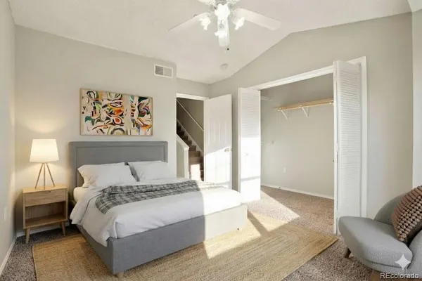 a spacious bedroom with a bed and glass walk in closet