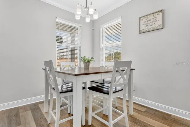a dining room with wooden floor and windows