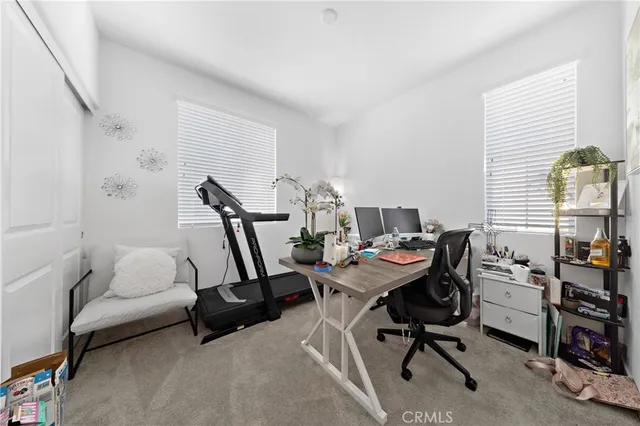 a view of a workspace with furniture and a window